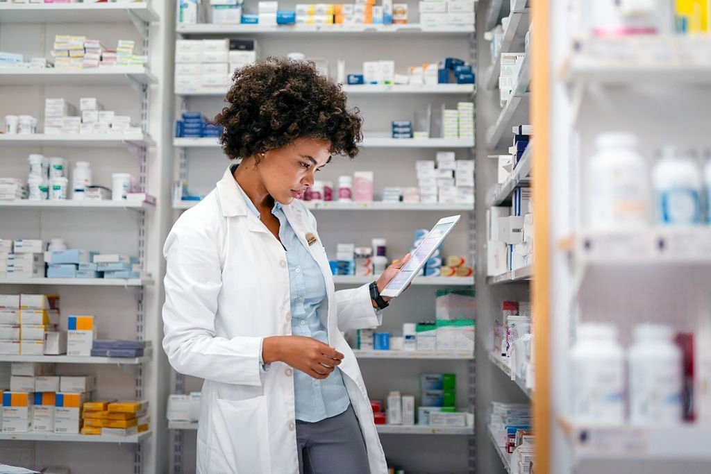 Pharmacist organizing medications on shelves at Medihub Pharmacy
